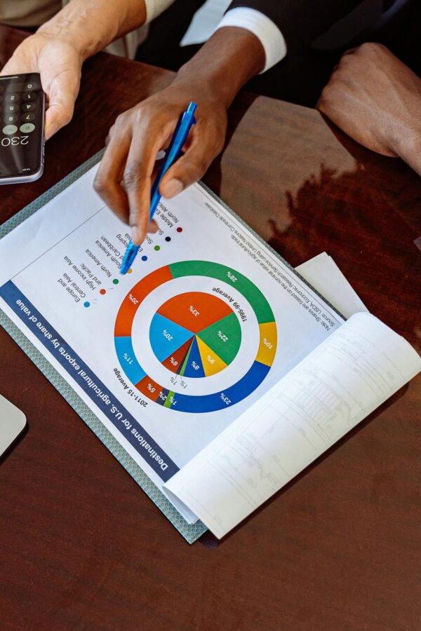 Two business professionals discussing financial documents and strategies at an office desk.