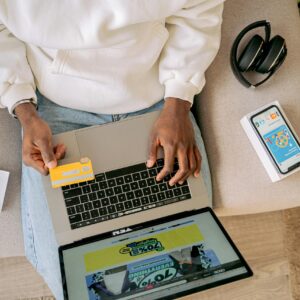 Person shopping online with a credit card on a laptop, emphasizing convenience and technology.